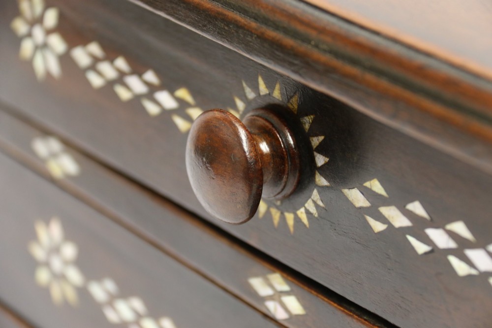 A dark hardwood tabletop chest featuring three drawers decorated with geometric bone inlay and turned wooden knobs. View XI