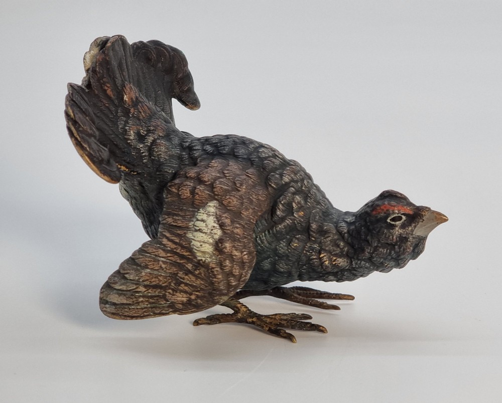 A cold painted bronze sculpture depicting a capercaillie in a display pose with textured dark brown feathers and red eye accents. View V