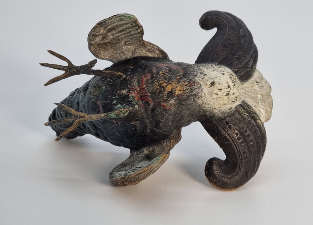 A cold painted bronze sculpture depicting a capercaillie in a display pose with textured dark brown feathers and red eye accents. View VI
