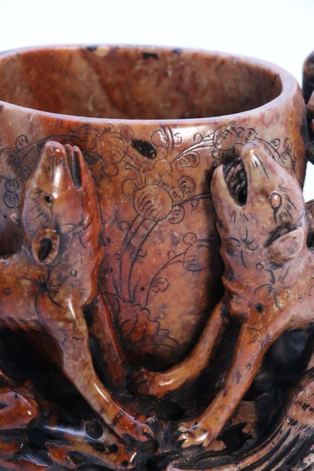 A cylindrical reddish-brown carved soapstone brush pot featuring sculpted animal figures in high relief surrounding an engraved vessel. View XIV