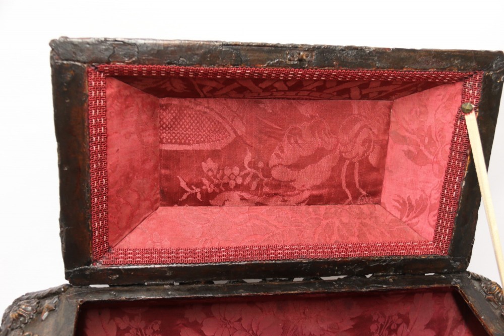 An early 19th-century sarcophagus-shaped gesso casket featuring raised classical relief panels, rope-twist borders, lion mask ring handles, and claw feet. View VII