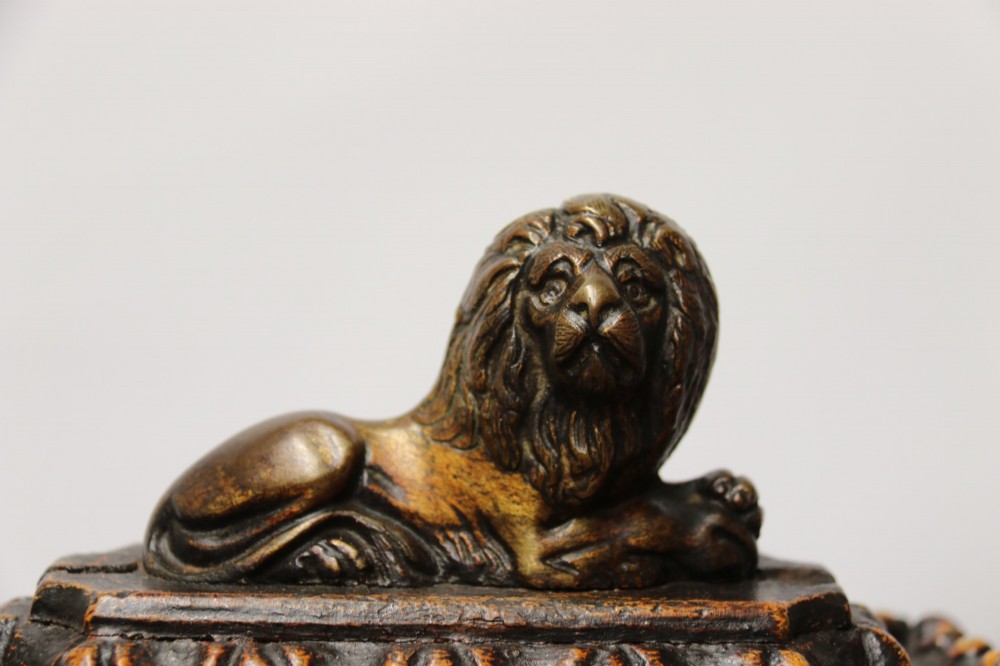 An early 19th-century sarcophagus-shaped gesso casket featuring raised classical relief panels, rope-twist borders, lion mask ring handles, and claw feet. View VIII