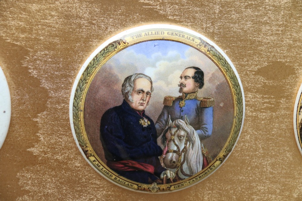 A large rectangular ornate gilt frame displaying thirty-five circular Victorian polychrome transfer-printed ceramic pot lids mounted in grid formation. View VI