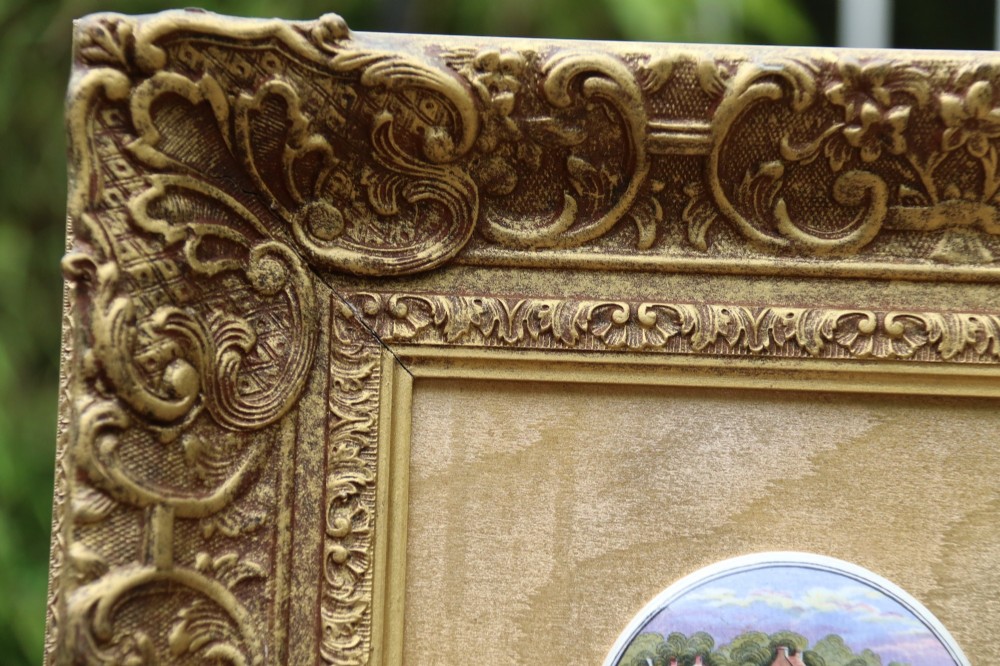 A large rectangular ornate gilt frame displaying thirty-five circular Victorian polychrome transfer-printed ceramic pot lids mounted in grid formation. View XIII
