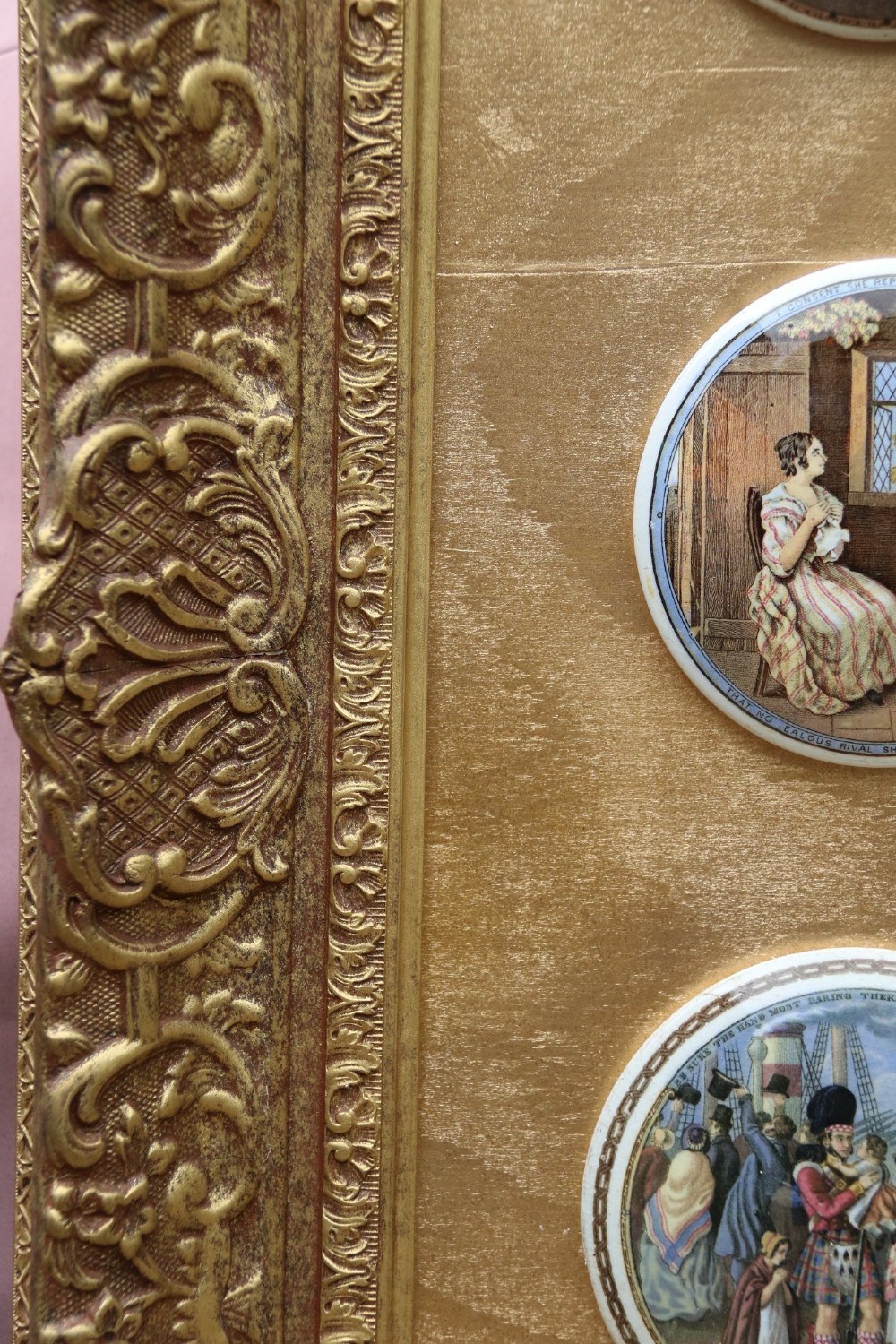 A large rectangular ornate gilt frame displaying thirty-five circular Victorian polychrome transfer-printed ceramic pot lids mounted in grid formation. View XIV