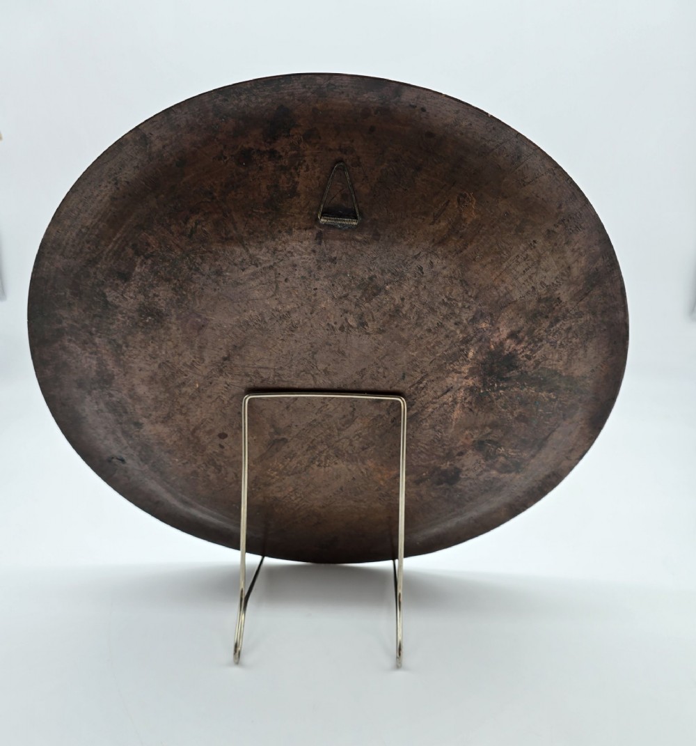 A circular antique Egyptian Cairo Ware wall charger made of dark copper intricately inlaid with silver depicting Pharaonic figures, pyramids, and hieroglyphs. View III