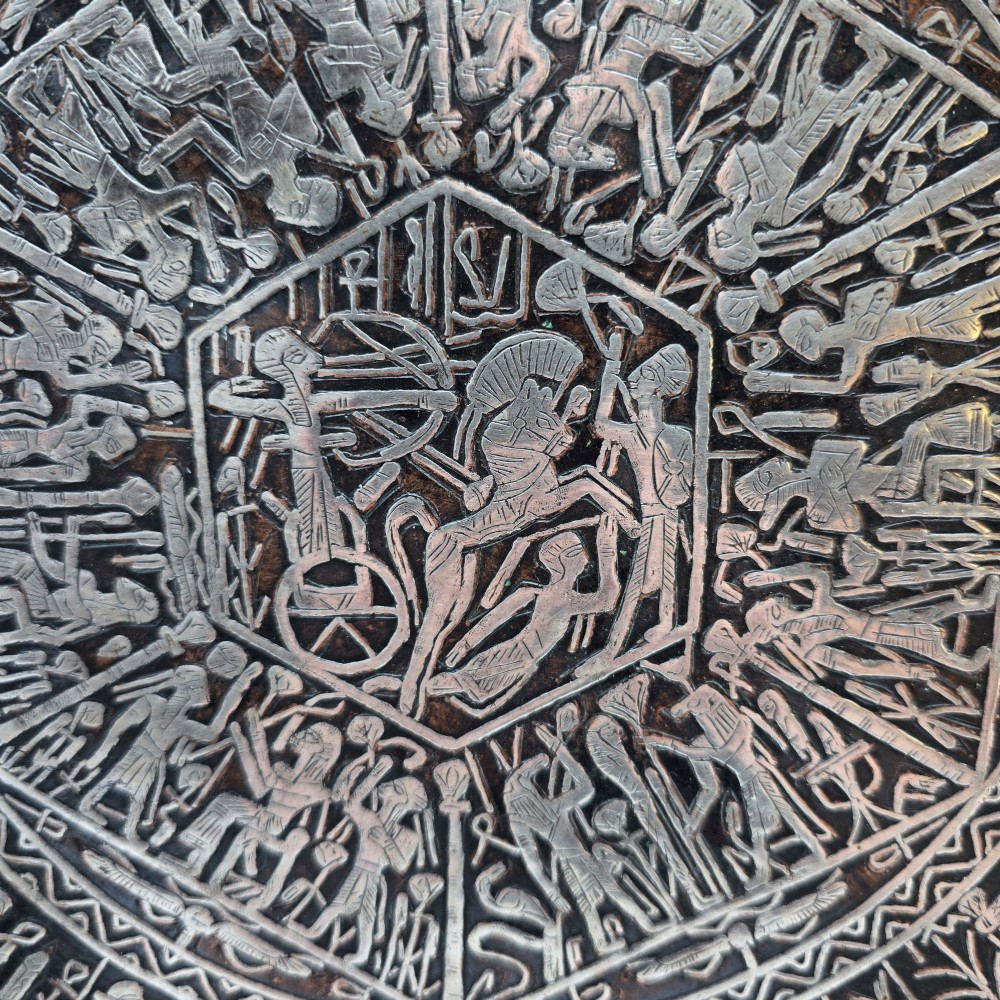 A circular antique Egyptian Cairo Ware wall charger made of dark copper intricately inlaid with silver depicting Pharaonic figures, pyramids, and hieroglyphs. View IV