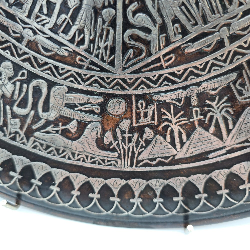 A circular antique Egyptian Cairo Ware wall charger made of dark copper intricately inlaid with silver depicting Pharaonic figures, pyramids, and hieroglyphs. View V
