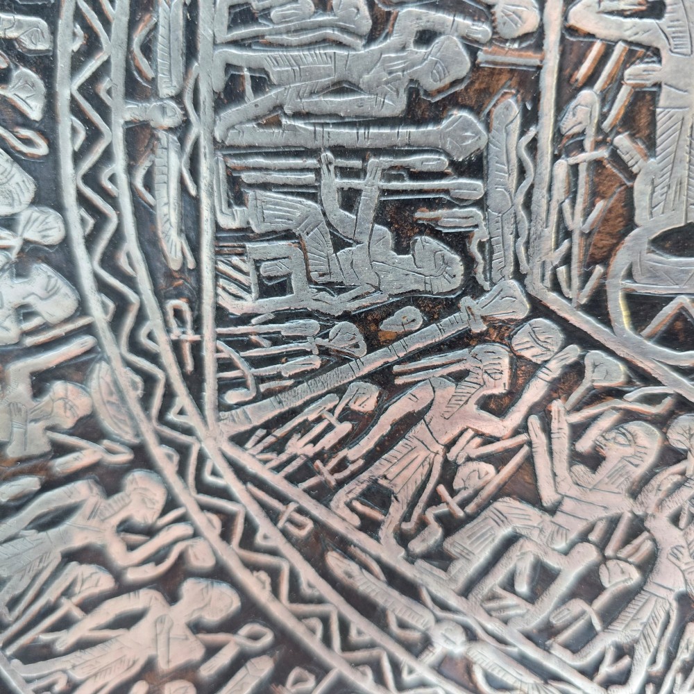 A circular antique Egyptian Cairo Ware wall charger made of dark copper intricately inlaid with silver depicting Pharaonic figures, pyramids, and hieroglyphs. View VI
