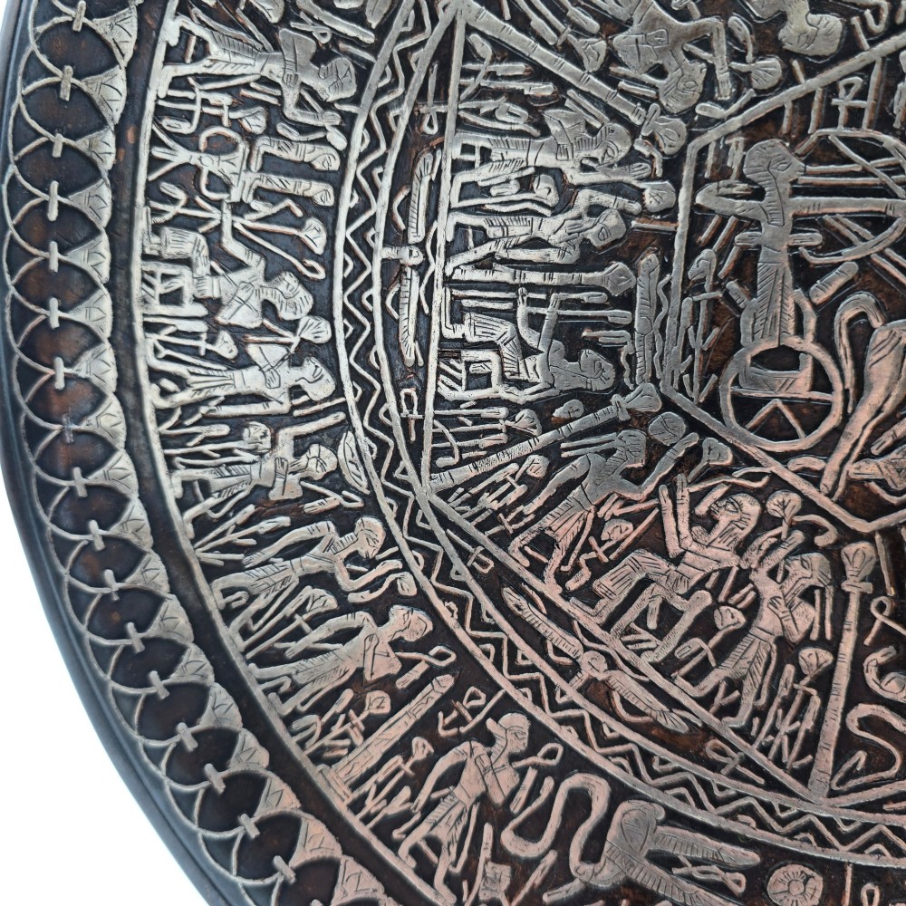 A circular antique Egyptian Cairo Ware wall charger made of dark copper intricately inlaid with silver depicting Pharaonic figures, pyramids, and hieroglyphs. View X