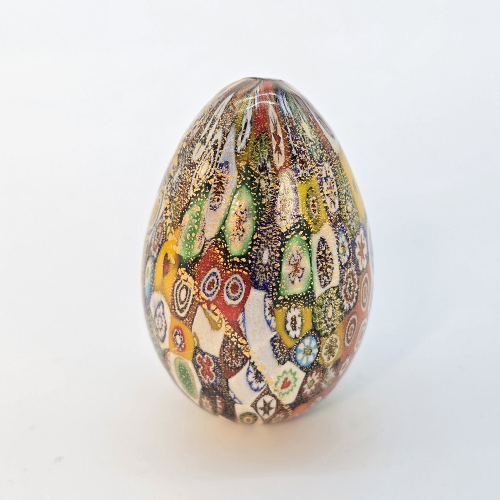 An egg-shaped Murano glass paperweight featuring colourful millefiori cane patterns and gold aventurine inclusions throughout. View II
