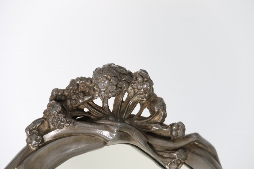 An Art Nouveau pewter table mirror featuring an asymmetrical botanical frame with organic crests and an easel back support. View II