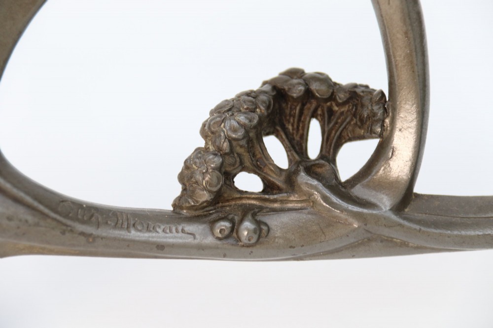 An Art Nouveau pewter table mirror featuring an asymmetrical botanical frame with organic crests and an easel back support. View VII