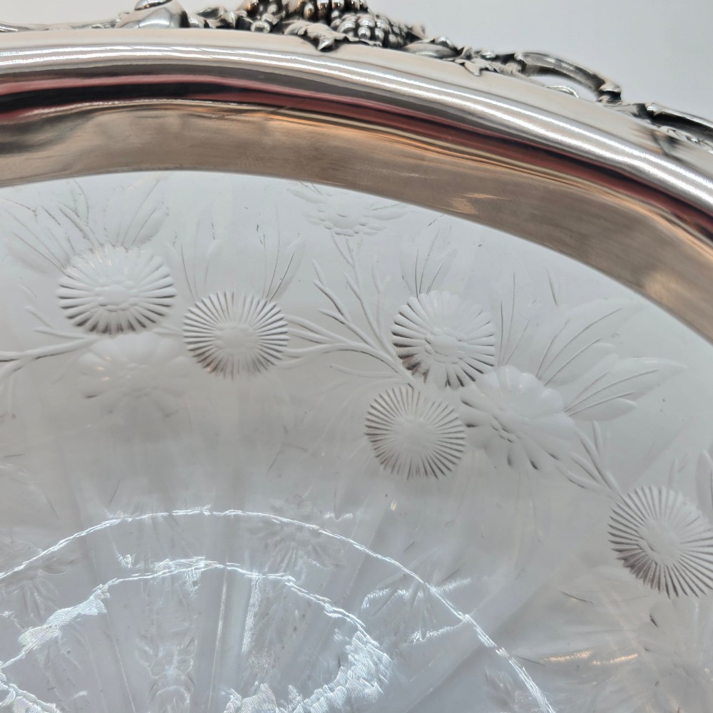 A clear crystal bowl featuring an intricately chased sterling silver rim decorated with floral motifs, scrolls, and lattice patterns. View VI