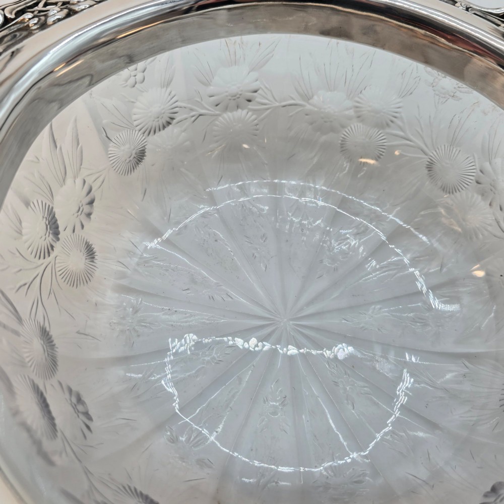 A clear crystal bowl featuring an intricately chased sterling silver rim decorated with floral motifs, scrolls, and lattice patterns. View VII