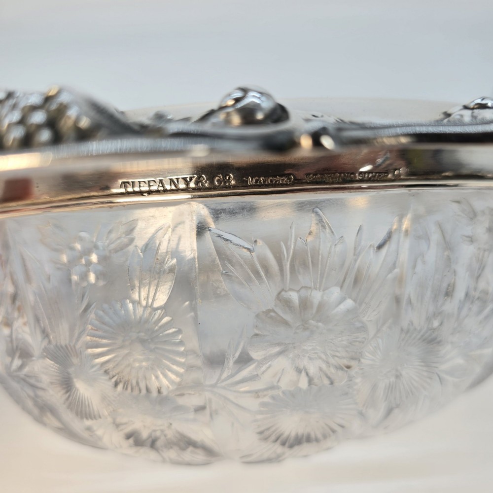 A clear crystal bowl featuring an intricately chased sterling silver rim decorated with floral motifs, scrolls, and lattice patterns. View XII