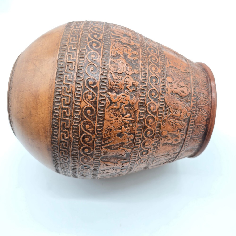 A round terracotta vase decorated with bands of relief-carved Greek classical figures, scrollwork, and geometric meander patterns. View V