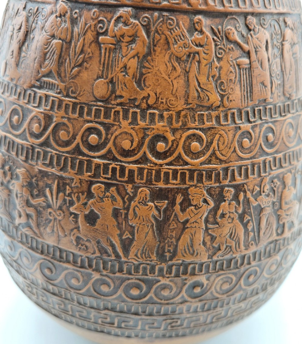 A round terracotta vase decorated with bands of relief-carved Greek classical figures, scrollwork, and geometric meander patterns. View VII