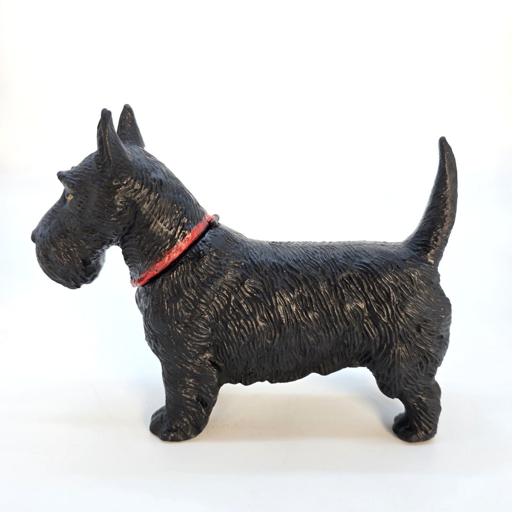 A hand-painted black cast metal table lighter shaped as a standing Scottish Terrier dog with a red collar. View V