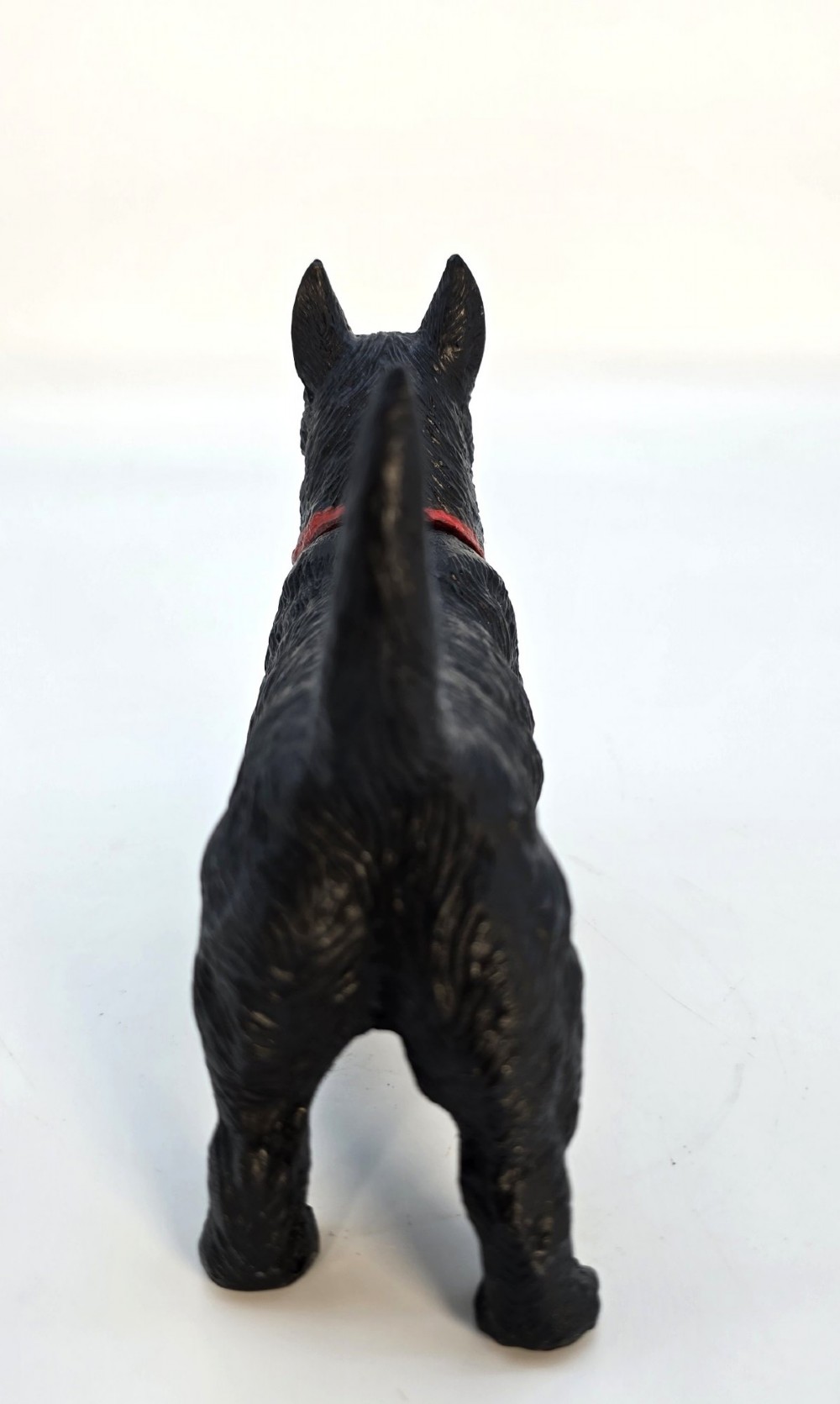 A hand-painted black cast metal table lighter shaped as a standing Scottish Terrier dog with a red collar. View VI