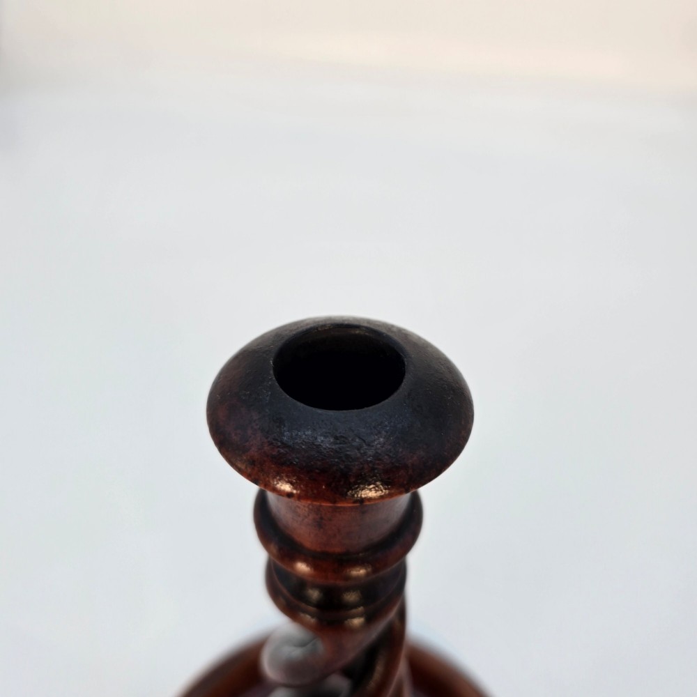 A pair of 18th-century carved fruitwood candlesticks featuring open twist stems and wide circular bases. View VII