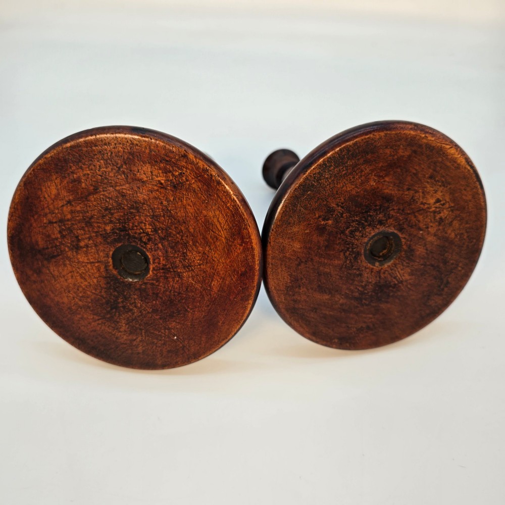 A pair of 18th-century carved fruitwood candlesticks featuring open twist stems and wide circular bases. View VIII