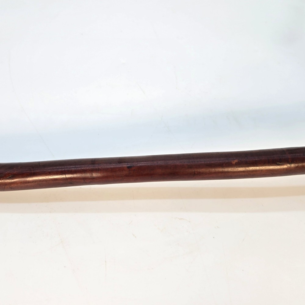An antique dark hardwood Zulu knobkerrie club featuring a faceted spherical head and a slender shaft with raised carved rings near the top. View V