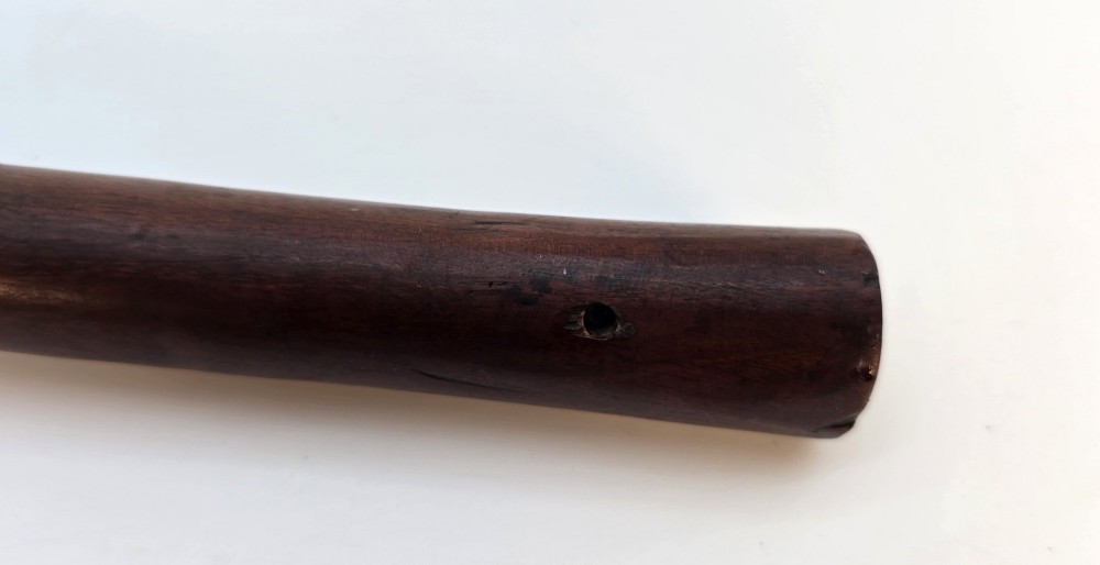 An antique dark hardwood Zulu knobkerrie club featuring a faceted spherical head and a slender shaft with raised carved rings near the top. View VI