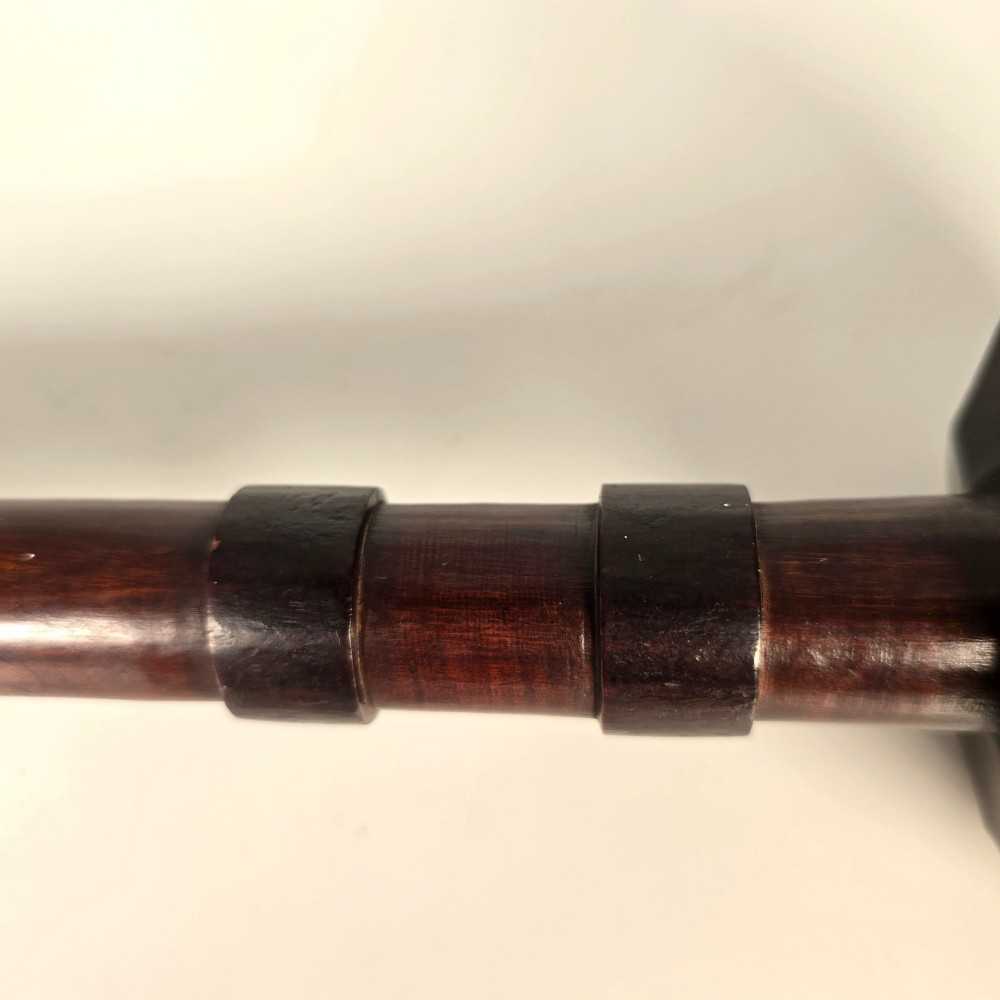 An antique dark hardwood Zulu knobkerrie club featuring a faceted spherical head and a slender shaft with raised carved rings near the top. View IX