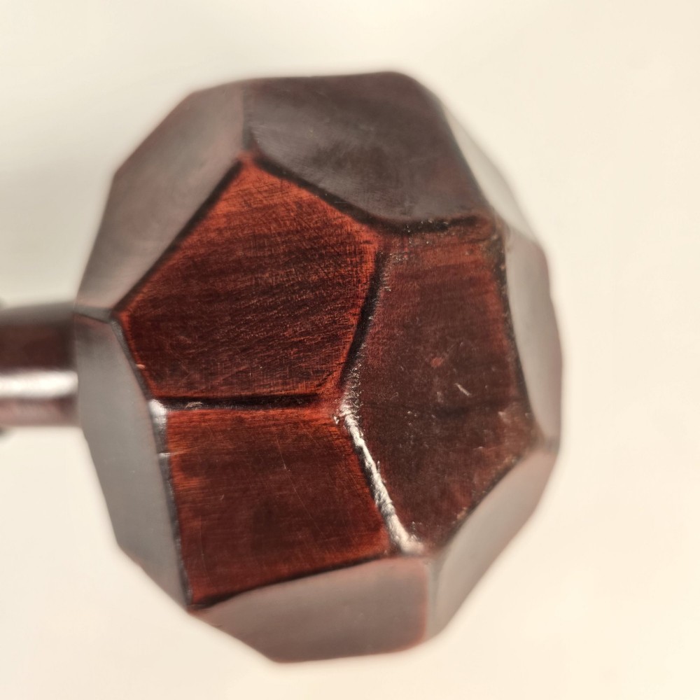 An antique dark hardwood Zulu knobkerrie club featuring a faceted spherical head and a slender shaft with raised carved rings near the top. View X