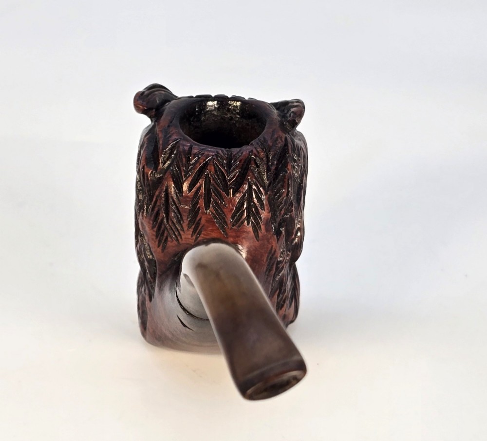 A detailed hand-carved briar wood tobacco pipe crafted in the shape of an owls head featuring yellow glass eyes and a curved black stem. View V