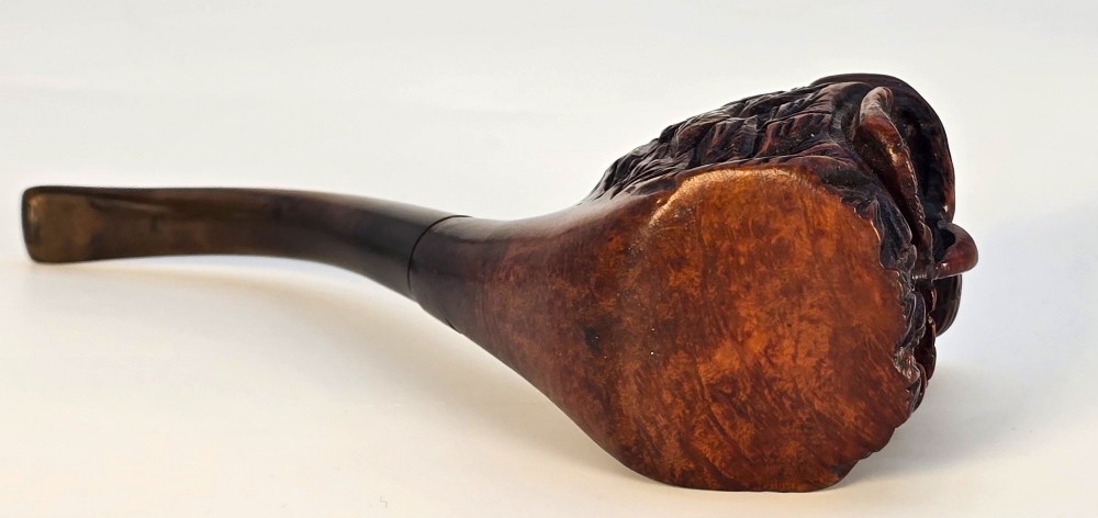 A detailed hand-carved briar wood tobacco pipe crafted in the shape of an owls head featuring yellow glass eyes and a curved black stem. View X