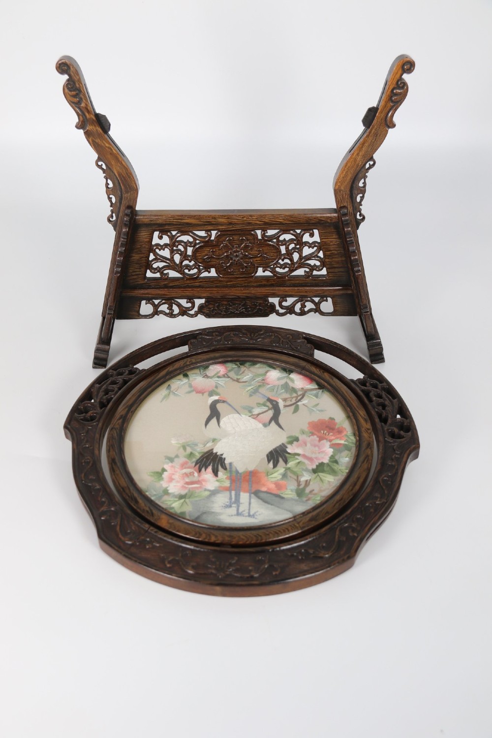 A circular double-sided silk embroidery depicting cranes among pink flowers, set within a rotating carved dark hardwood frame and stand. View XIII