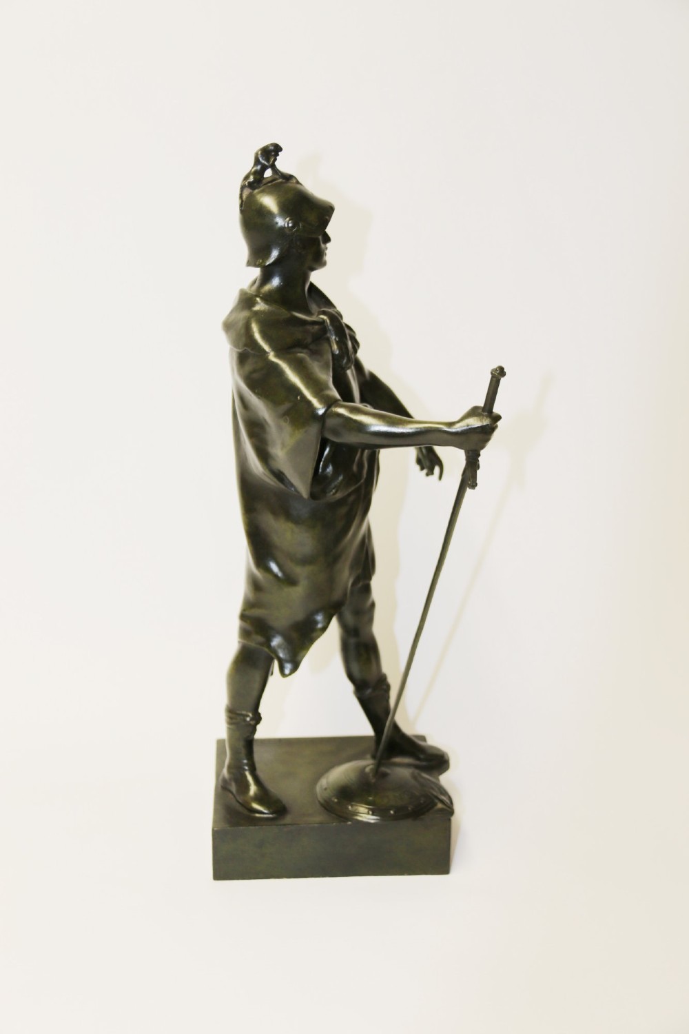 A late 19th-century patinated dark bronze sculpture depicting a Roman warrior with a sword resting against a shield on a rectangular base. View XI