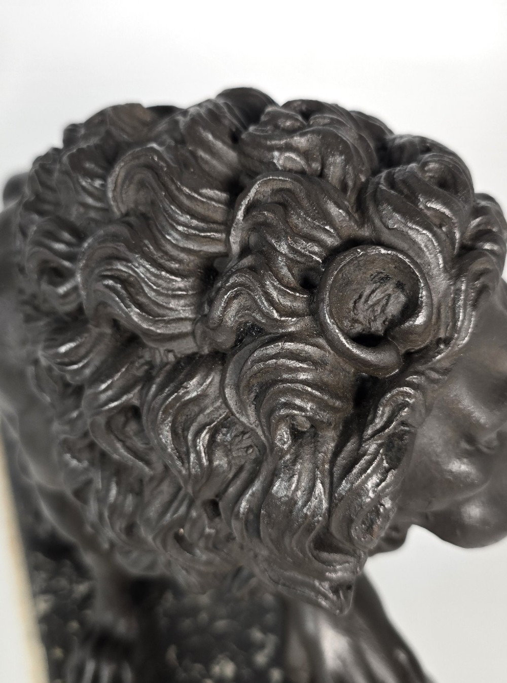 A dark patinated bronze sculpture of a lion resting its paw on a sphere, mounted on a two-tier marble plinth. View XII
