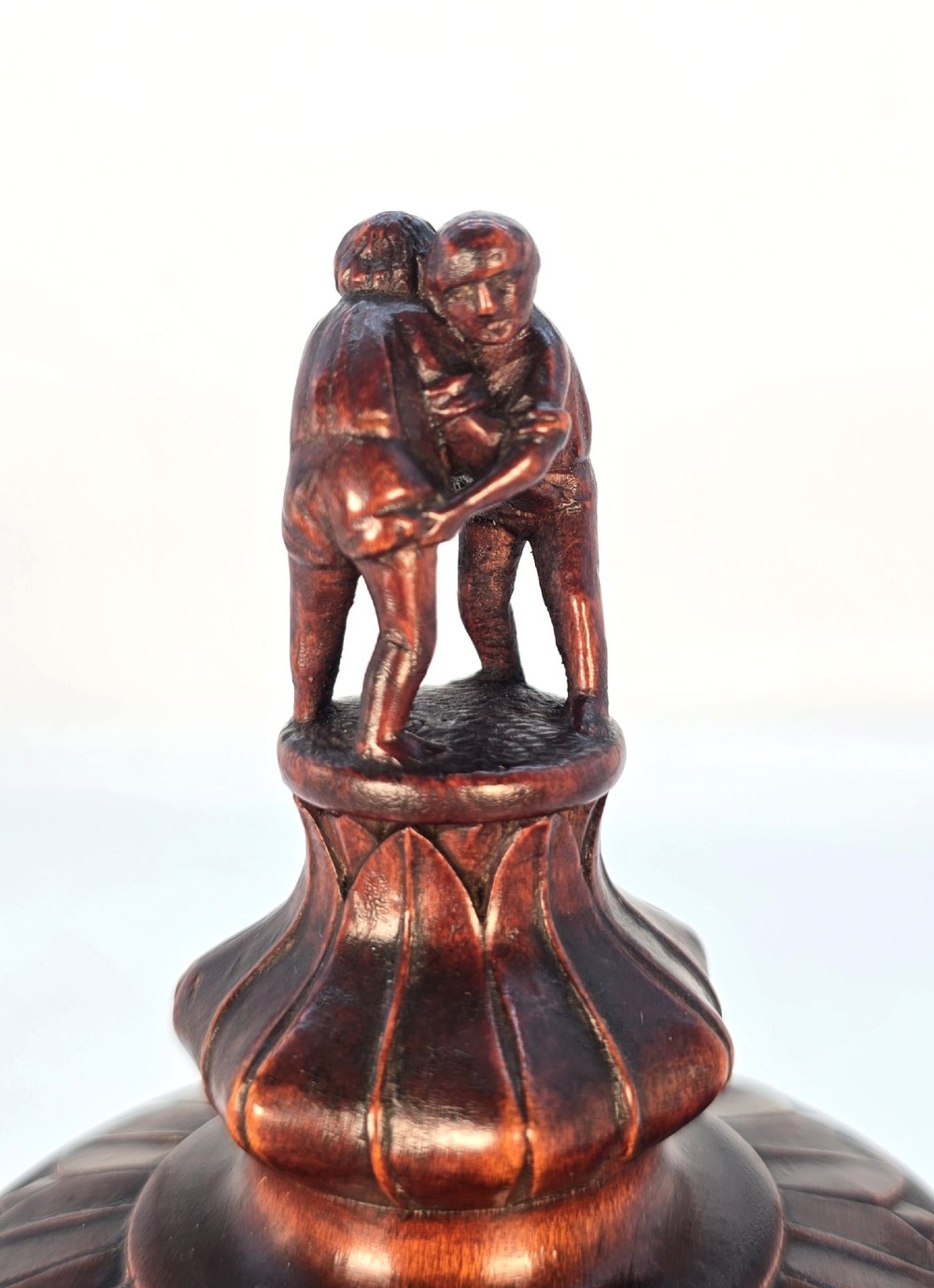 A tall hand-carved dark walnut lidded chalice featuring a stem sculpted as human figures, a relief carving of cattle around the vessel, and a finial with carved figures. View IX