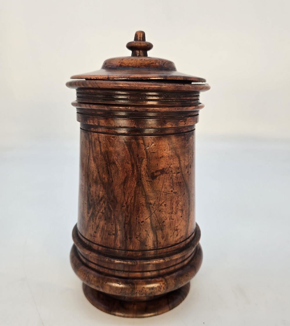 An 18th-century turned walnut wooden tobacco jar featuring a knopped finial lid, turned mouldings, and a dark aged grain surface. View II