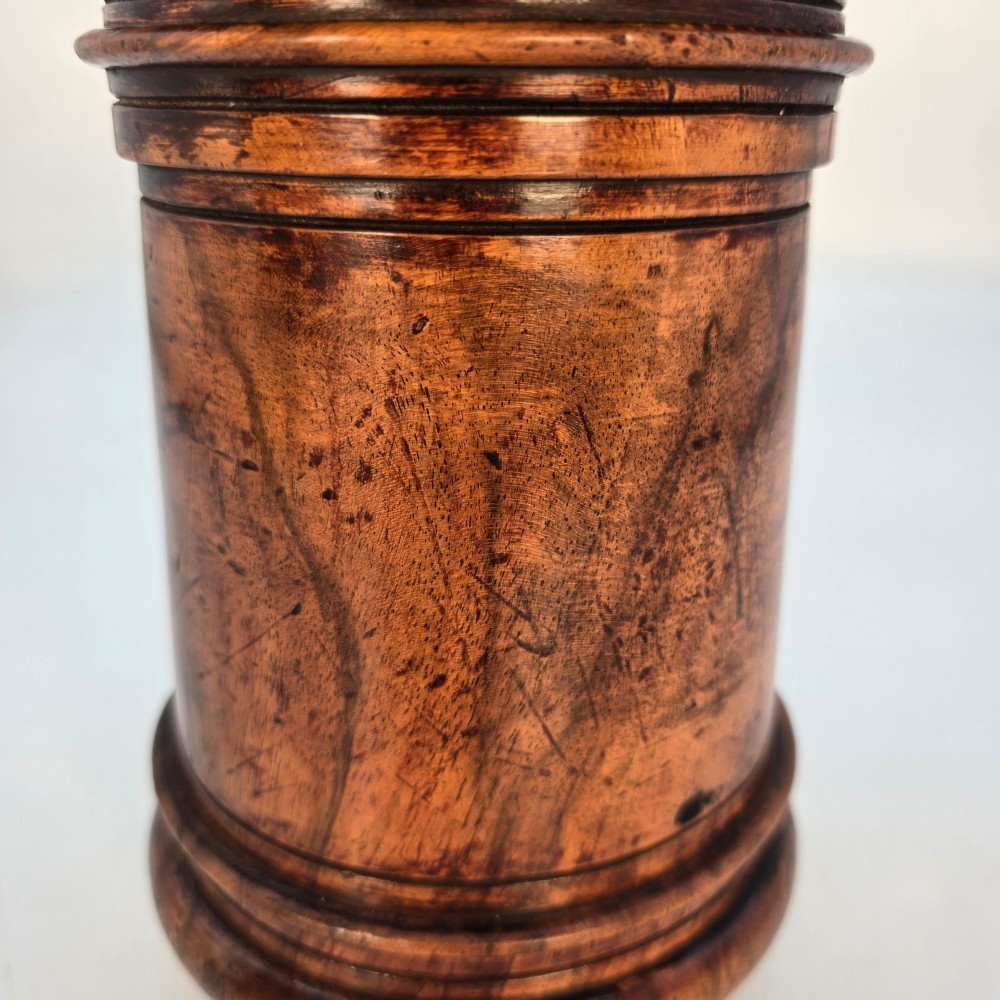 An 18th-century turned walnut wooden tobacco jar featuring a knopped finial lid, turned mouldings, and a dark aged grain surface. View XI