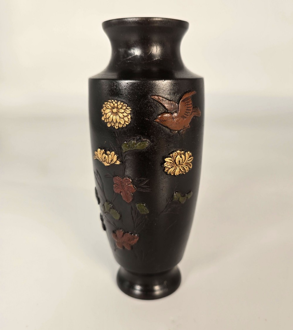 A dark brown patinated bronze Japanese vase featuring raised relief inlays of gold and copper chrysanthemums alongside a bird in flight. View II