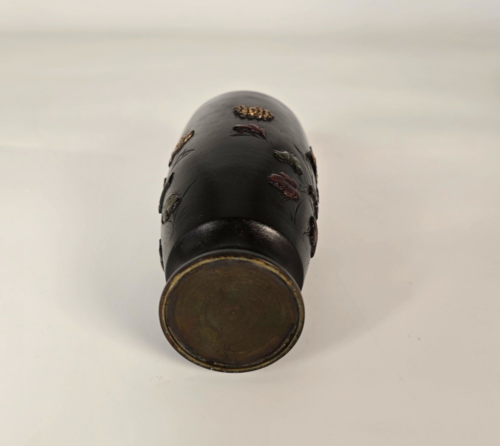 A dark brown patinated bronze Japanese vase featuring raised relief inlays of gold and copper chrysanthemums alongside a bird in flight. View X