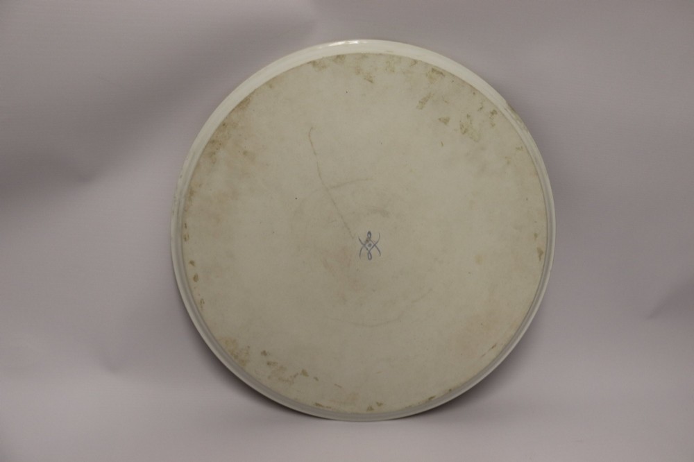 A large round porcelain charger with a deep burgundy border edged in gold leaf, featuring a central hand-painted scene depicting a historic battle with figures on horseback. View XIII