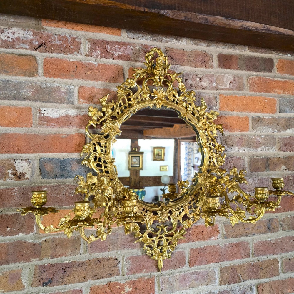 A 19th-century French ormolu girandole wall mirror featuring an ornate foliage frame, central oval mirror, and six branching candle arms. View II