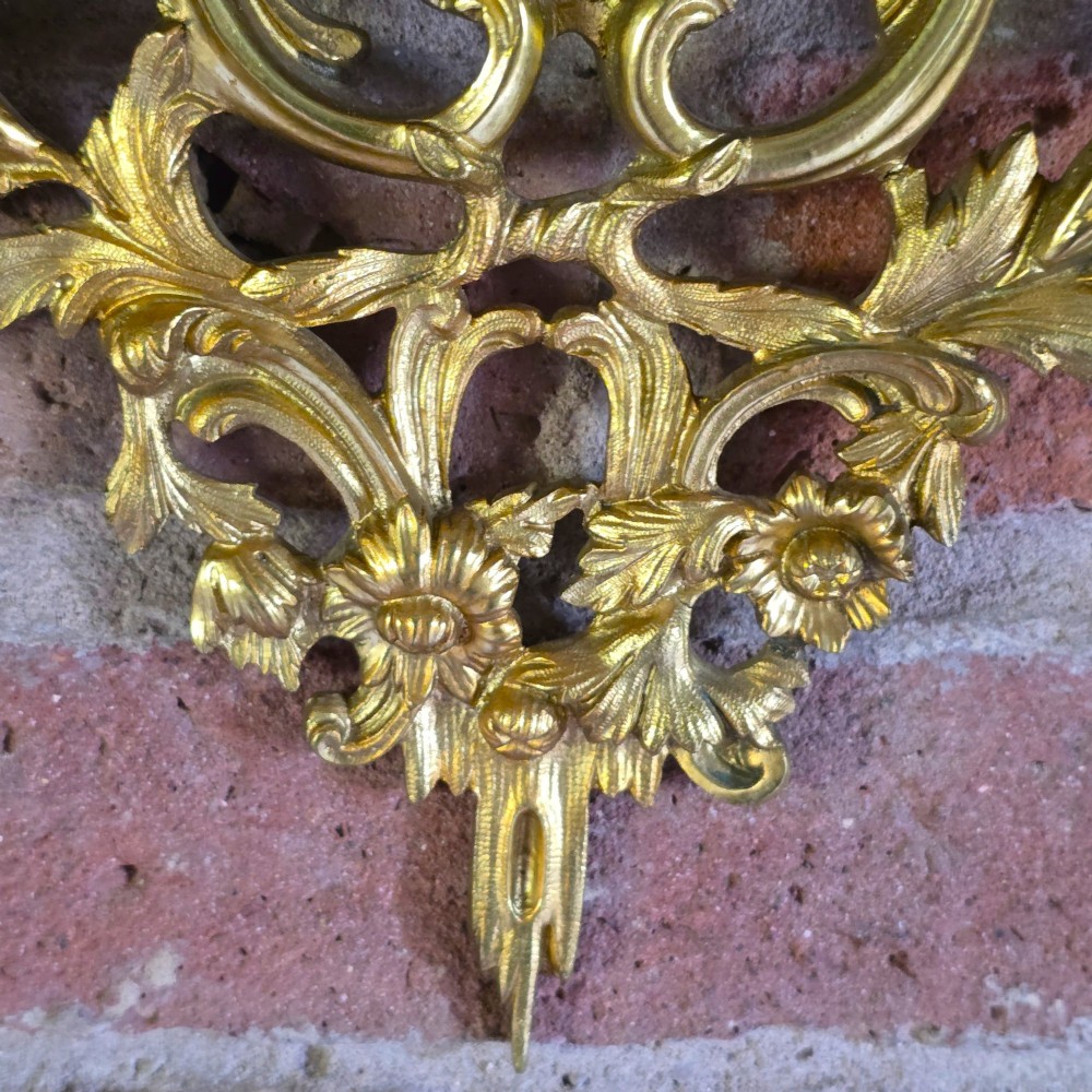 A 19th-century French ormolu girandole wall mirror featuring an ornate foliage frame, central oval mirror, and six branching candle arms. View IV