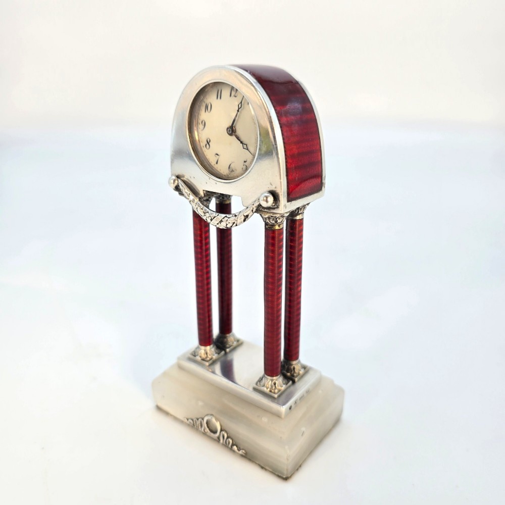 A Viennese silver and red guilloche enamel miniature portico desk clock mounted on a white onyx base. View III