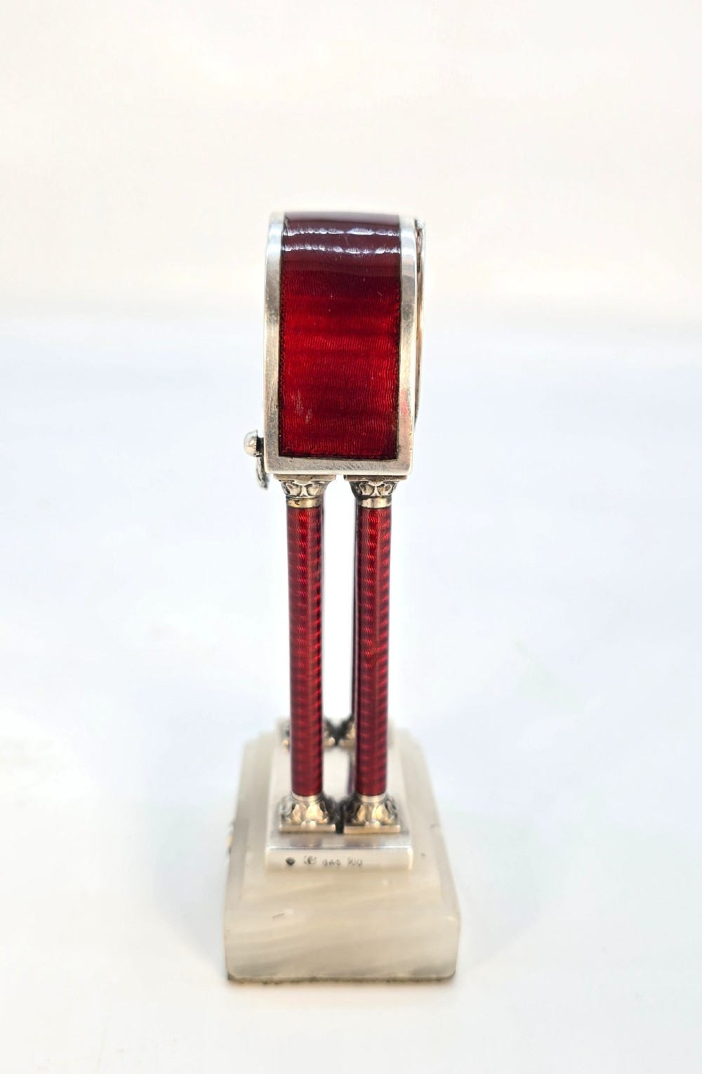 A Viennese silver and red guilloche enamel miniature portico desk clock mounted on a white onyx base. View IV