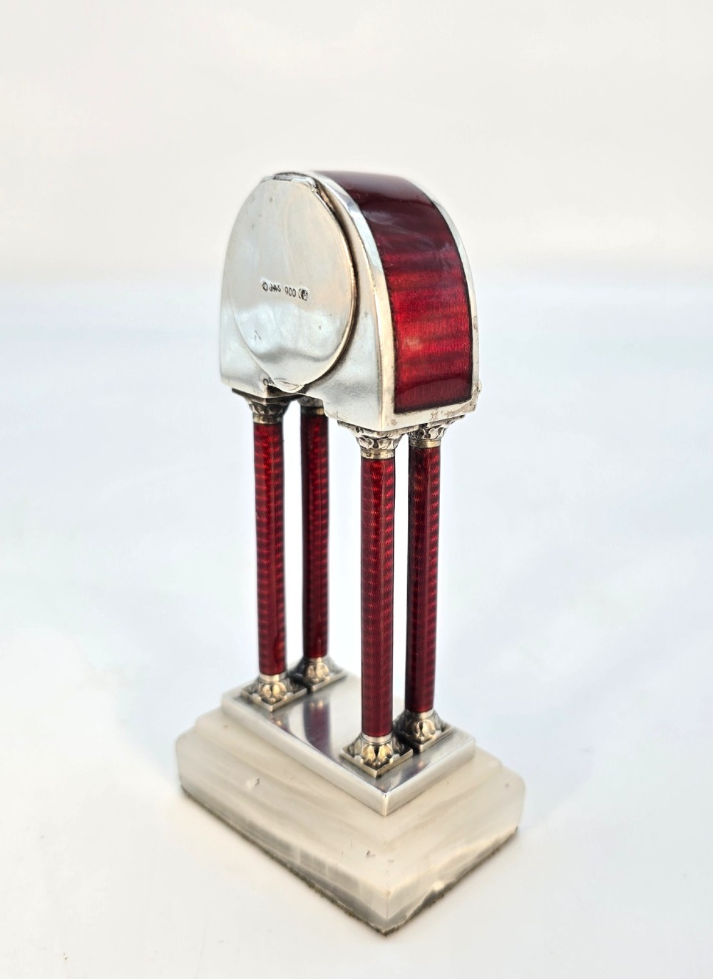 A Viennese silver and red guilloche enamel miniature portico desk clock mounted on a white onyx base. View VII