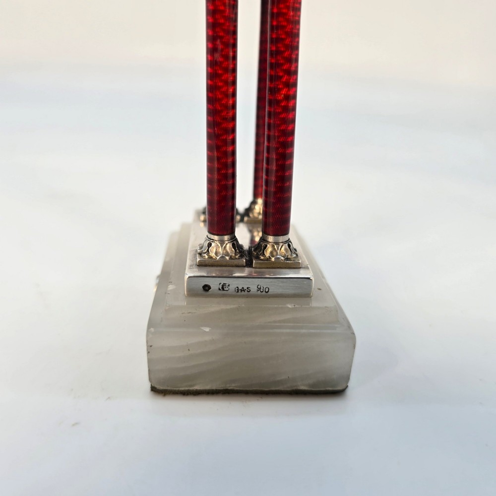 A Viennese silver and red guilloche enamel miniature portico desk clock mounted on a white onyx base. View XI
