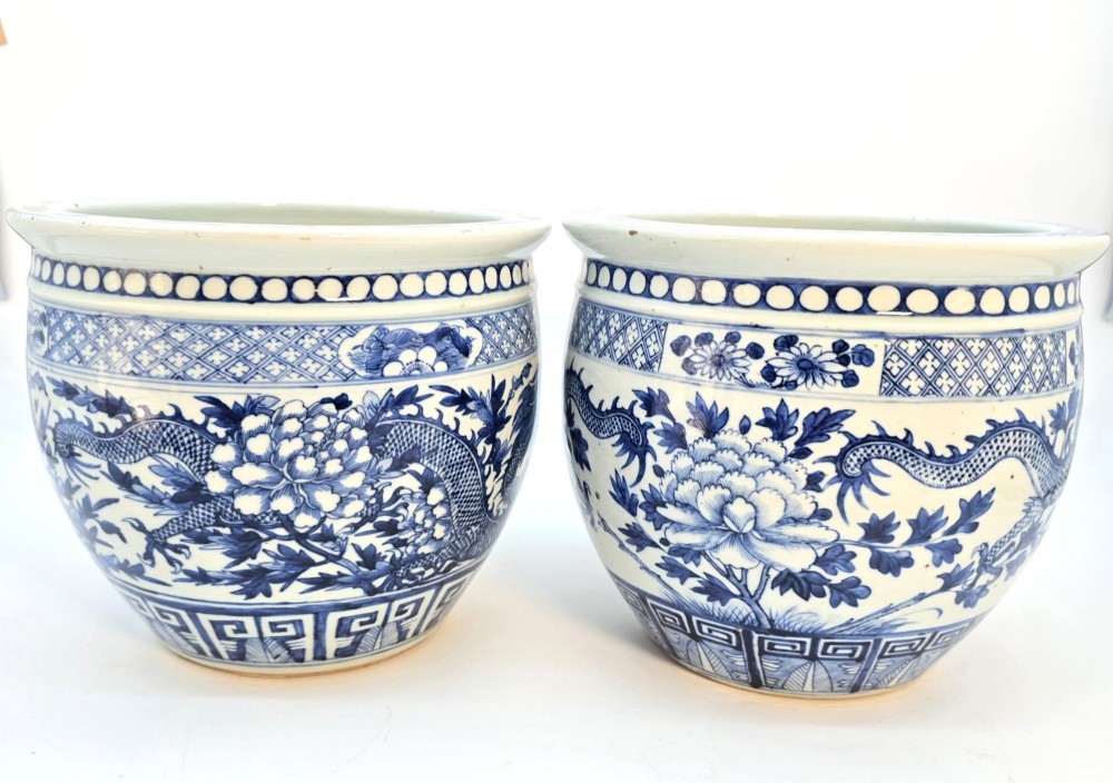 A pair of rounded Chinese porcelain jardinieres decorated with underglaze cobalt blue dragon and floral motifs. View II