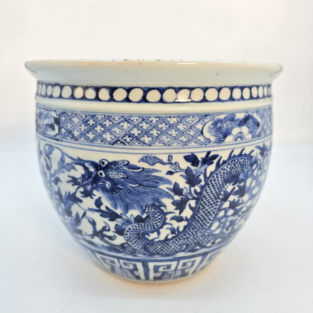A pair of rounded Chinese porcelain jardinieres decorated with underglaze cobalt blue dragon and floral motifs. View X