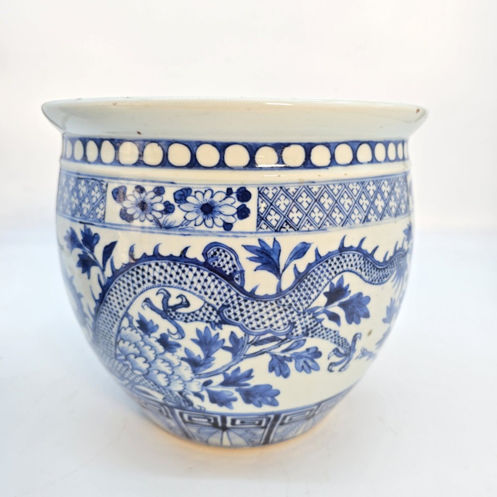 A pair of rounded Chinese porcelain jardinieres decorated with underglaze cobalt blue dragon and floral motifs. View XV